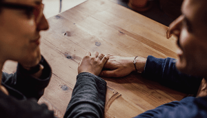 Two people holding hands on a table
