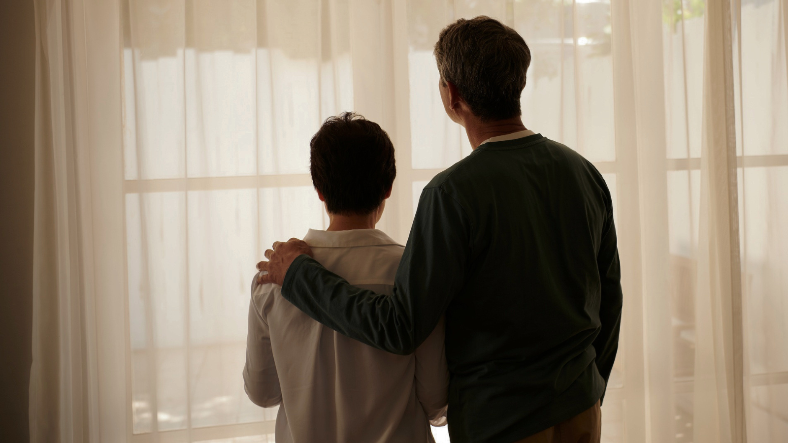 A man puts his arm around his partner