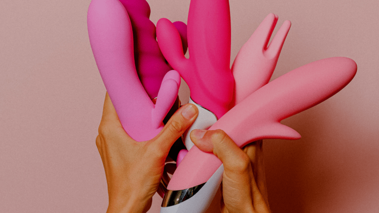 Hands holding a variety of vibrators and dildos