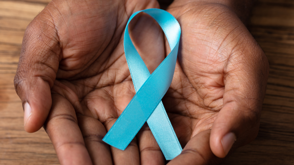 A person holds a teal ribbon in their hands