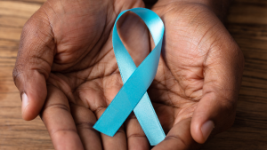 A person holds a teal ribbon in their hands