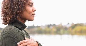 An African American woman looks pensively in the distance