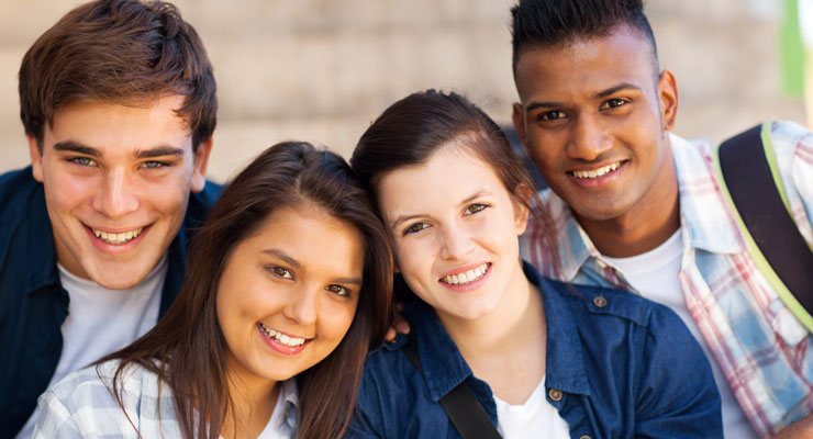 A group of four teens smiling