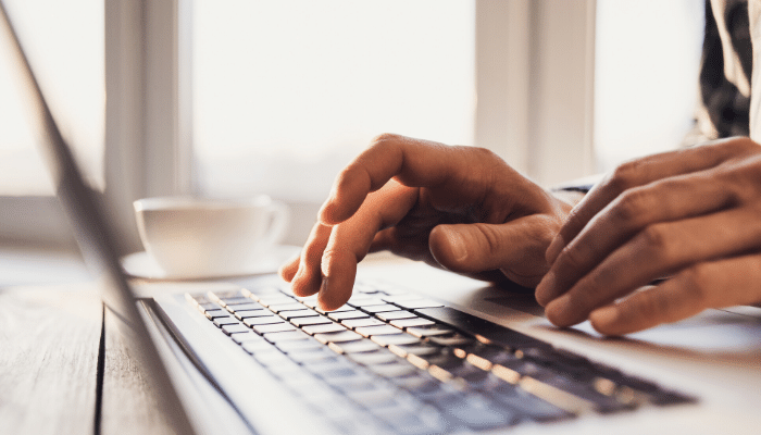 A person types on a laptop