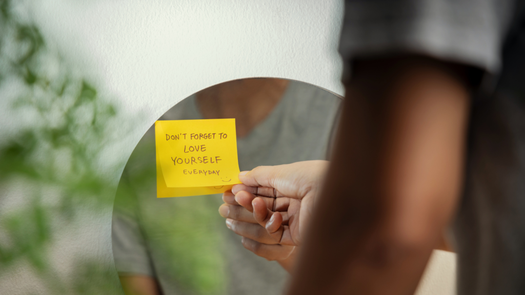 A person looks at a post-it note on a mirror