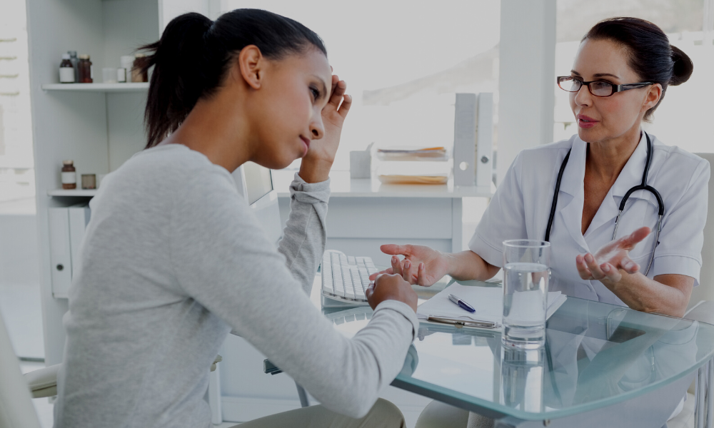 A doctor talking to a patient who appears uncomfortable