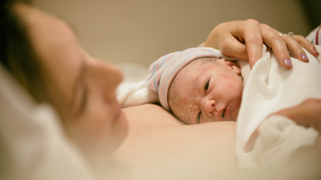 A newborn lies on their mother's chest