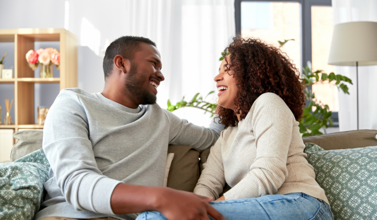 A couple sitting on a sofa laughing