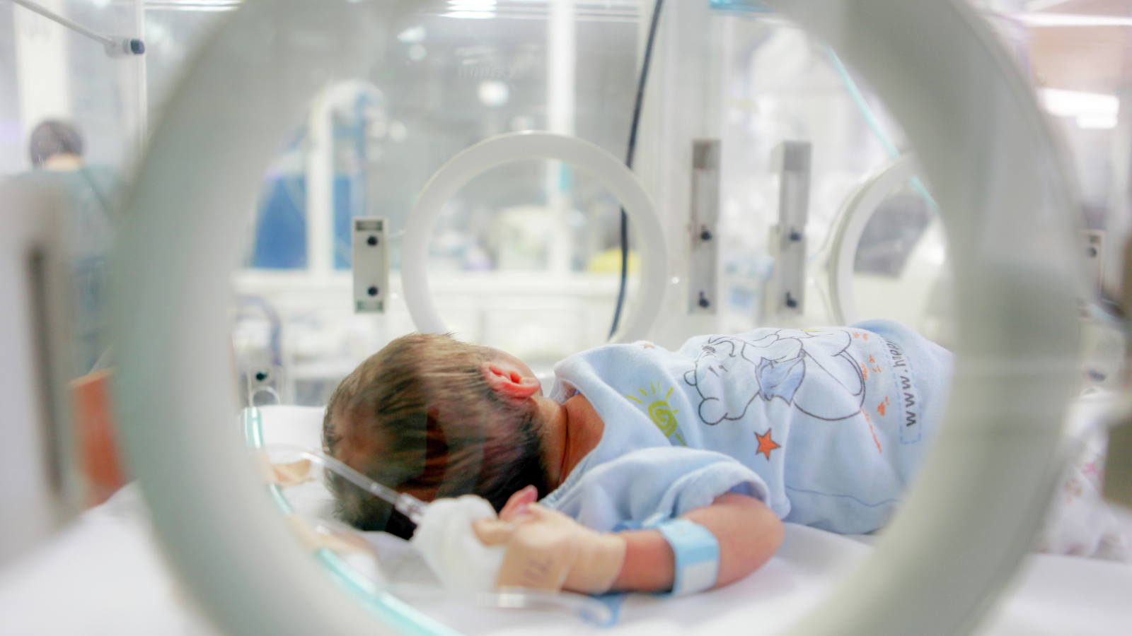 An infant is in an incubator in the NICU