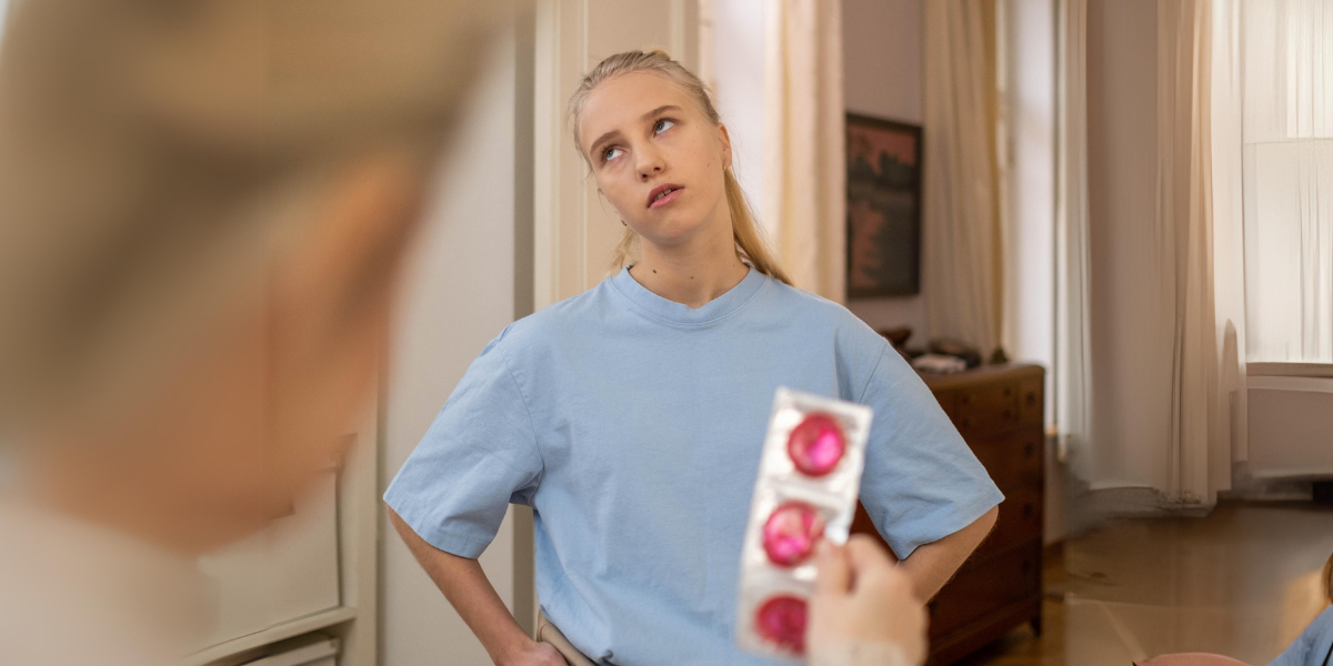 A teen is offered condoms and rolls their eyes