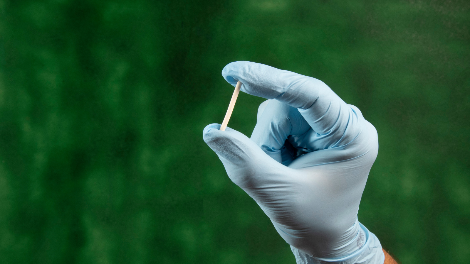 A gloved hand holds a contraceptive impalnt