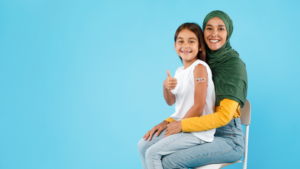 A child sits on her mother's lap after getting vaccinated