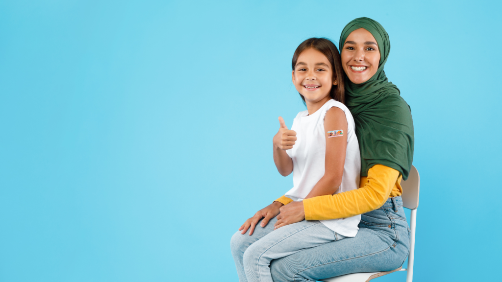 A child sits on her mother's lap after getting vaccinated