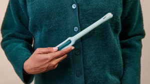 A woman holds a Teal Wand, a device for at-home cervical cancer screening