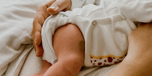 An infant with a bandage where a vaccine was administered