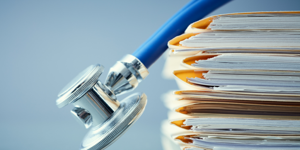 A stethoscope hangs over file folders