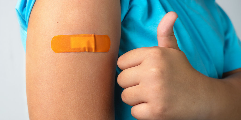 An adolescent gives a thumbs up after getting a vaccine